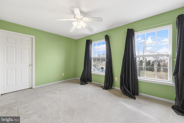 unfurnished bedroom featuring light colored carpet and ceiling fan