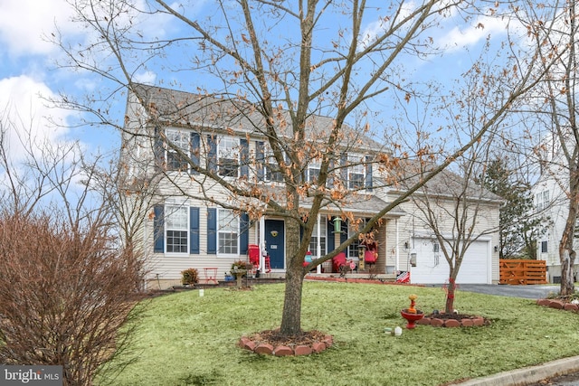 colonial inspired home featuring a garage and a front yard