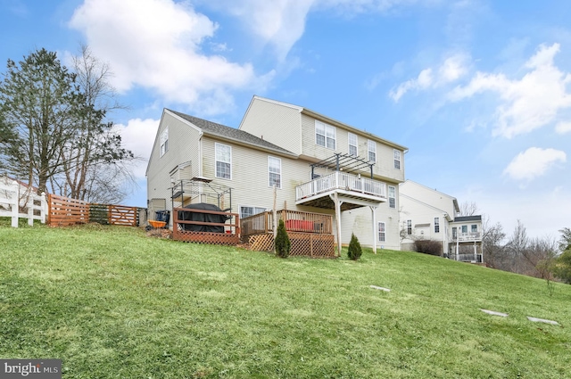 rear view of house featuring a deck and a lawn