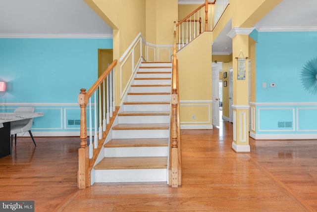 staircase featuring crown molding and hardwood / wood-style flooring