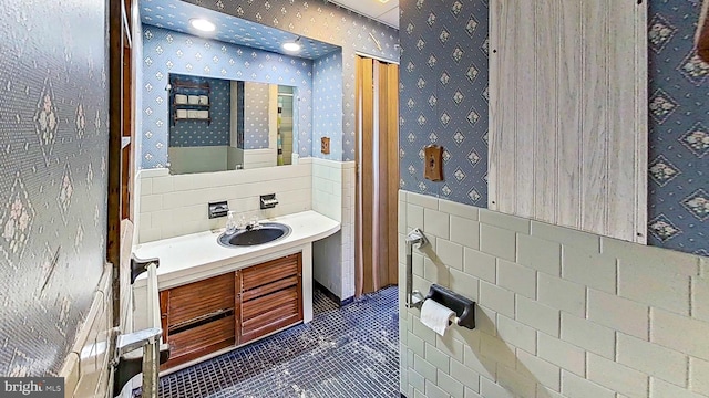 bathroom featuring tile patterned flooring, vanity, and tile walls