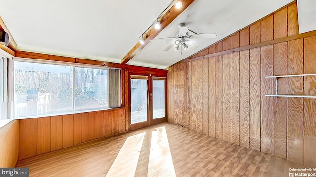 unfurnished sunroom featuring ceiling fan, rail lighting, and vaulted ceiling with beams