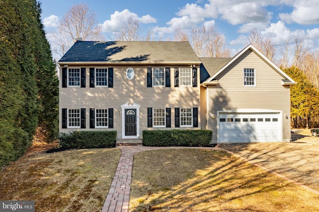 colonial home with a garage and a front yard