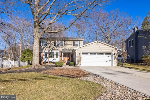 traditional home featuring a garage, driveway, a front yard, and fence