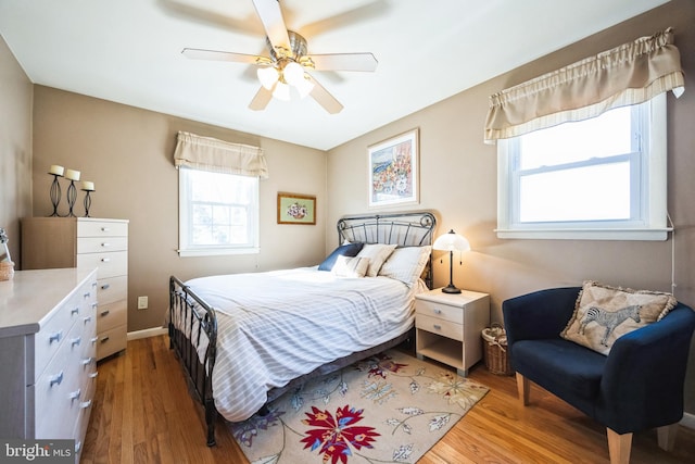 bedroom featuring a ceiling fan, light wood-style flooring, and baseboards