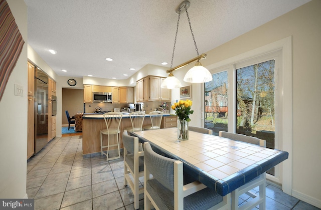 dining space with recessed lighting, a textured ceiling, baseboards, and light tile patterned floors