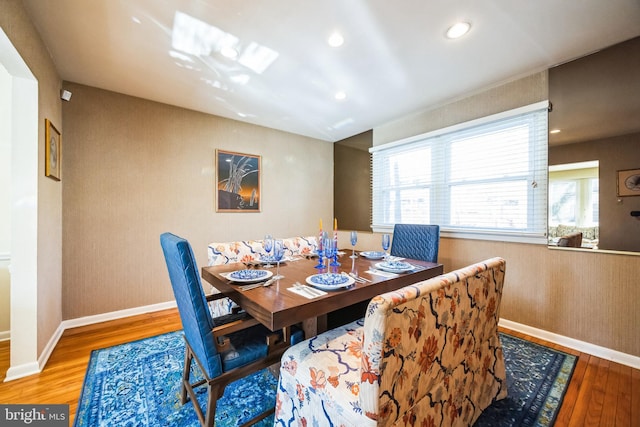 dining room featuring baseboards, wood finished floors, and recessed lighting