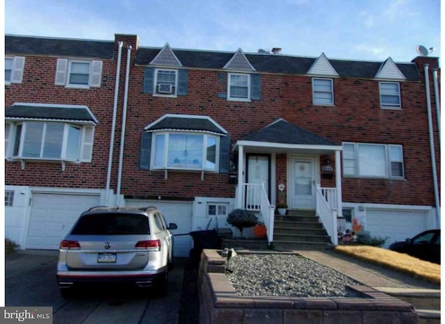 multi unit property featuring driveway, brick siding, and an attached garage