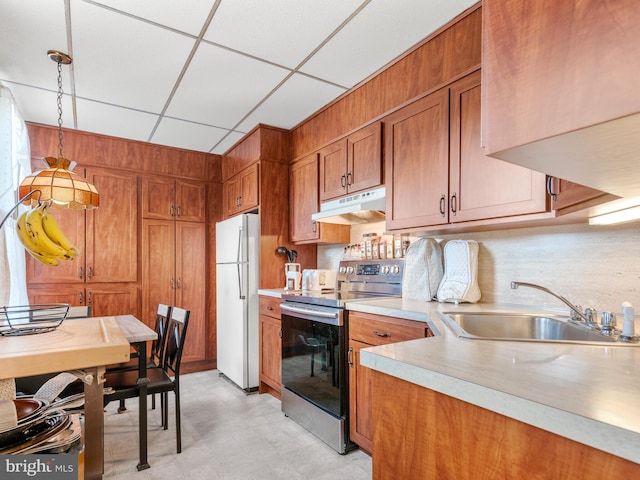 kitchen with pendant lighting, sink, stainless steel range with electric stovetop, white fridge, and a drop ceiling