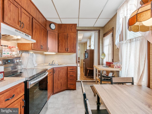 kitchen with tasteful backsplash, sink, electric range, and a paneled ceiling