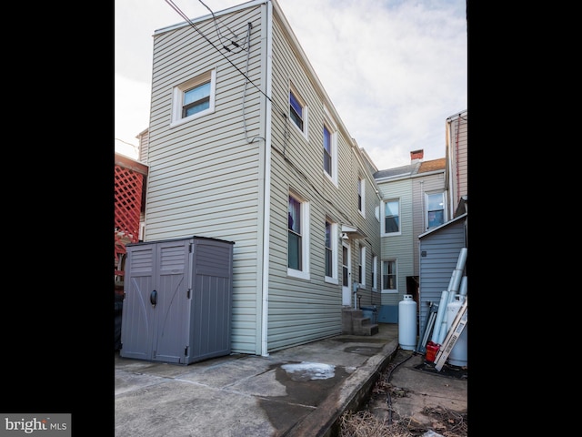 view of home's exterior with a storage unit