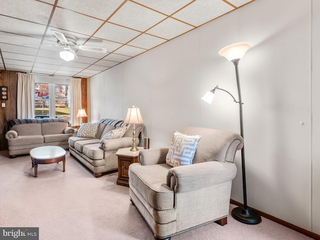 living room featuring carpet flooring, a drop ceiling, and ceiling fan