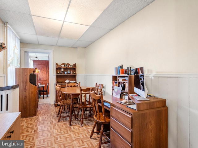 dining space with light parquet floors and a drop ceiling