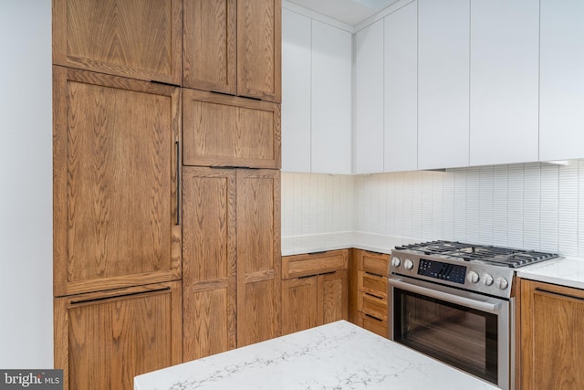 kitchen with stainless steel range with gas stovetop and decorative backsplash