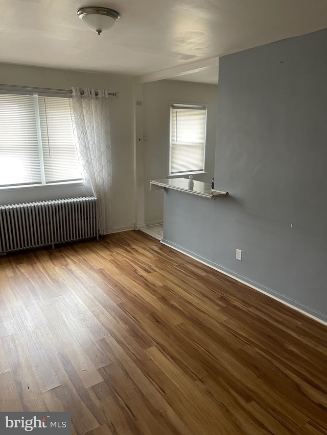 spare room with radiator and wood-type flooring