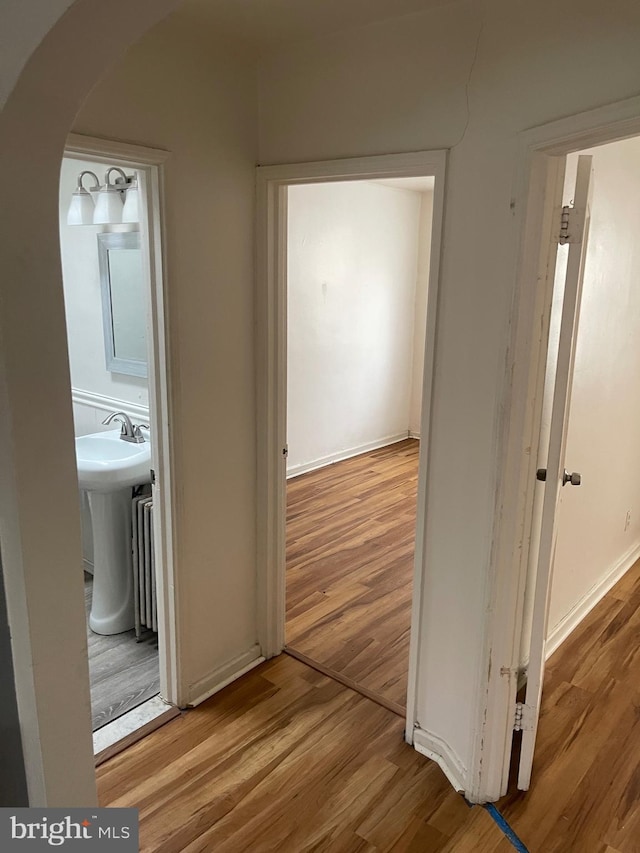 hallway featuring sink and hardwood / wood-style floors