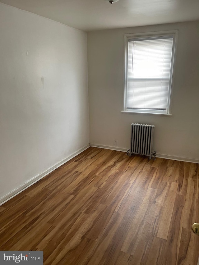 empty room with radiator and light wood-type flooring