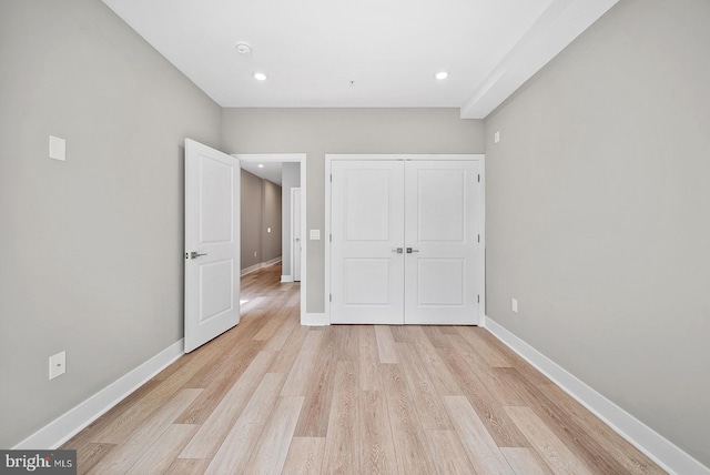 unfurnished bedroom with a closet and light hardwood / wood-style flooring