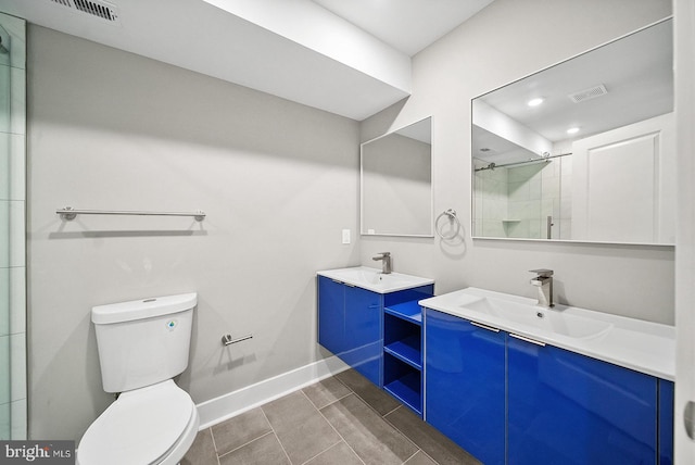 bathroom with vanity, a shower with door, and toilet