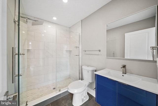 bathroom featuring vanity, a shower with door, tile patterned floors, and toilet