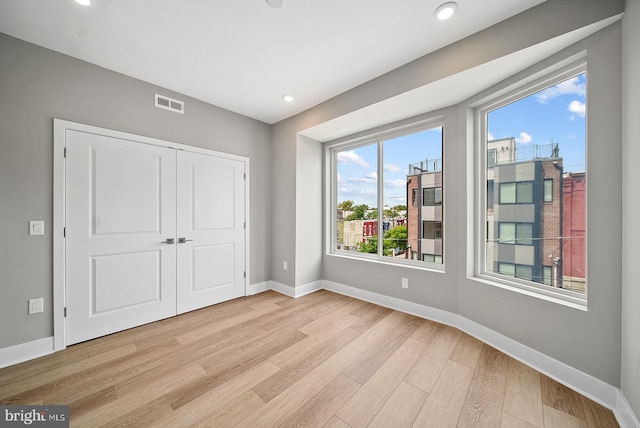 unfurnished bedroom with light hardwood / wood-style floors and a closet