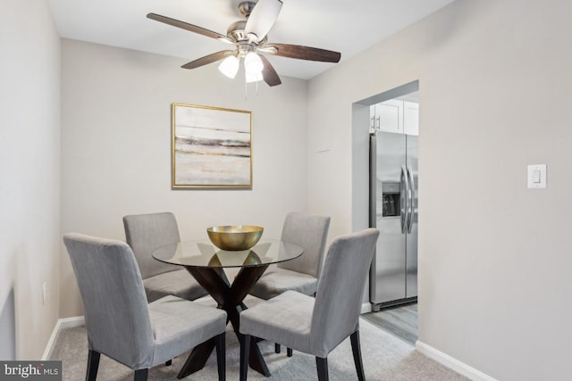 dining area featuring ceiling fan and light carpet