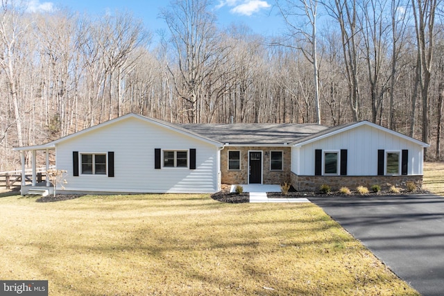 single story home featuring stone siding and a front lawn