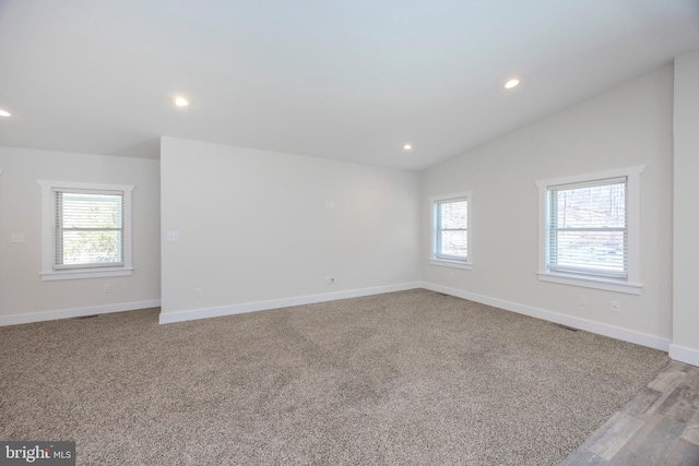 spare room with carpet floors, recessed lighting, vaulted ceiling, and baseboards