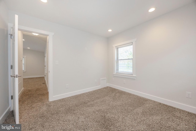 carpeted spare room featuring recessed lighting and baseboards