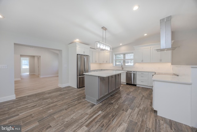 kitchen featuring stainless steel appliances, a sink, white cabinetry, light countertops, and island exhaust hood