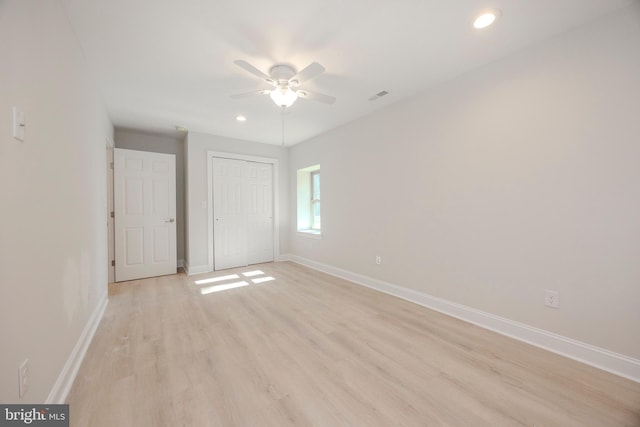 unfurnished bedroom featuring a closet, visible vents, light wood-style flooring, and baseboards