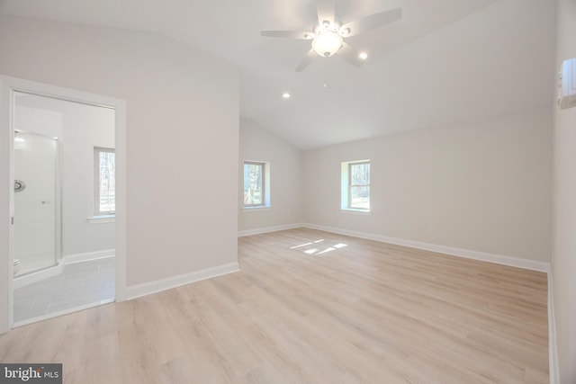 empty room featuring light wood finished floors, ceiling fan, baseboards, and vaulted ceiling