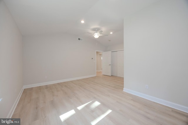 interior space with ceiling fan, visible vents, baseboards, vaulted ceiling, and light wood-type flooring