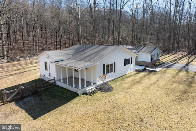 view of front of home with driveway, a front lawn, a shingled roof, and fence