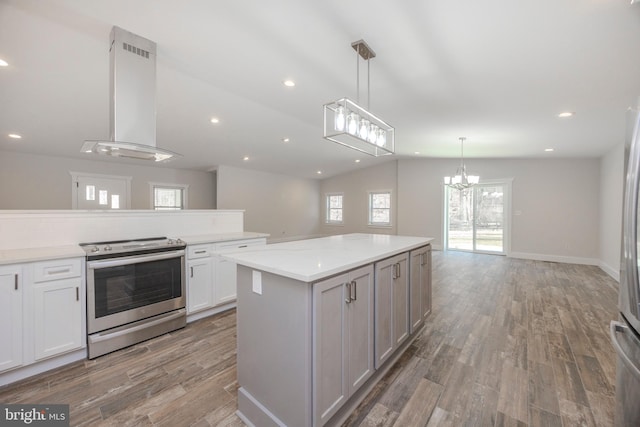 kitchen with electric range, lofted ceiling, wall chimney exhaust hood, light wood-style flooring, and open floor plan