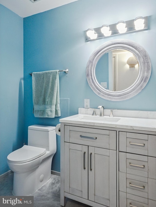 bathroom with toilet, baseboards, and vanity