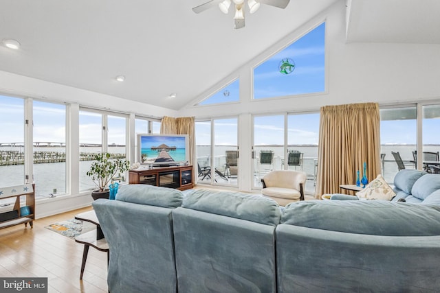 living room with light wood-type flooring, plenty of natural light, high vaulted ceiling, and ceiling fan