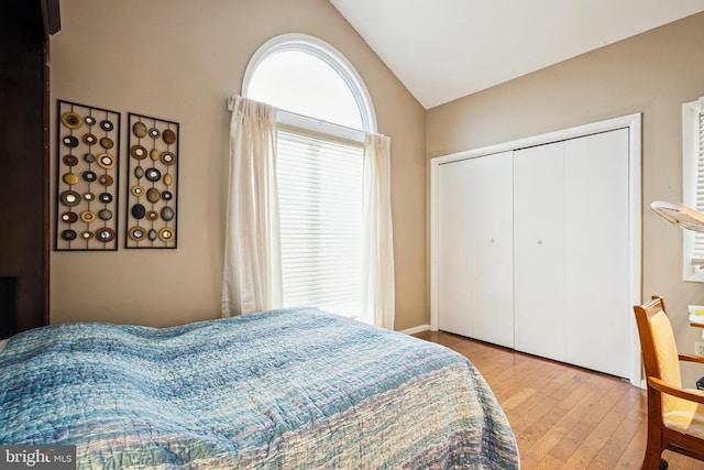 bedroom with a closet, vaulted ceiling, and wood finished floors