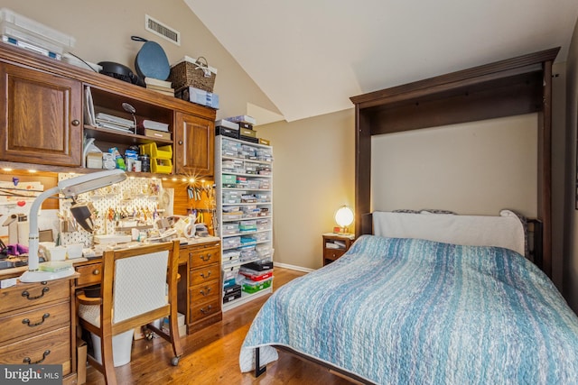 bedroom featuring lofted ceiling, light wood-style flooring, and visible vents