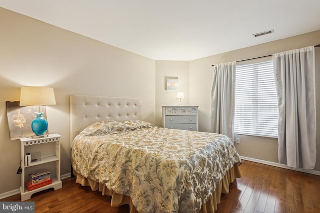 bedroom featuring baseboards, visible vents, and dark wood-style flooring