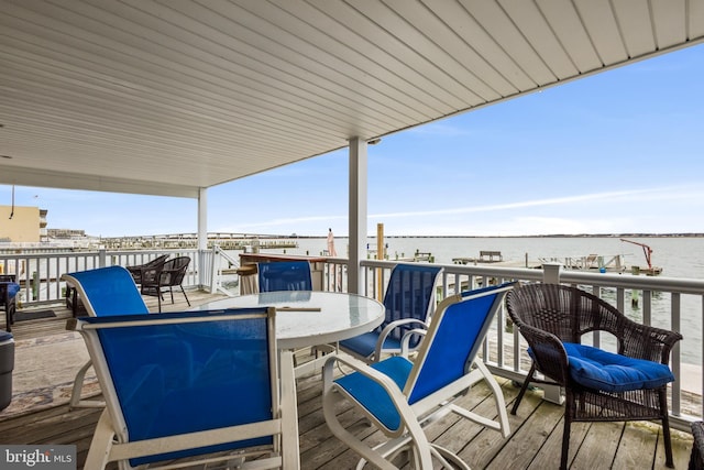 view of patio / terrace with outdoor dining space and a deck with water view