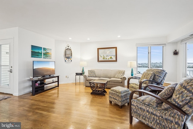 living area featuring baseboards, wood finished floors, and recessed lighting