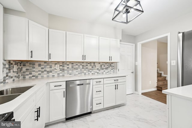 kitchen featuring stainless steel appliances, white cabinets, marble finish floor, light countertops, and decorative backsplash