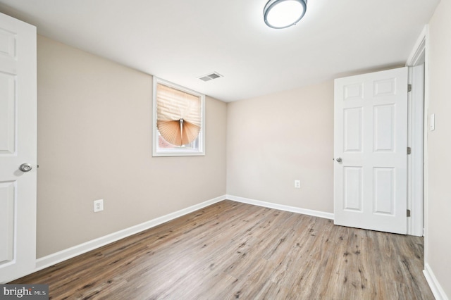 unfurnished bedroom with visible vents, light wood-style flooring, and baseboards