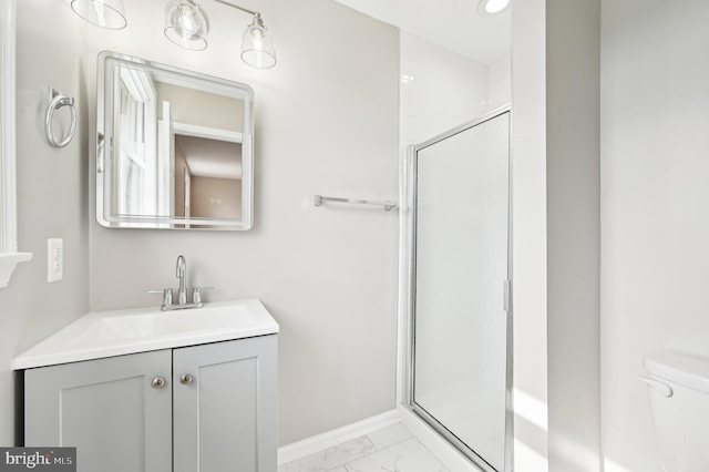 bathroom with marble finish floor, vanity, a shower stall, and toilet