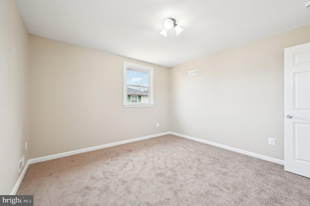 unfurnished room featuring carpet floors, visible vents, and baseboards