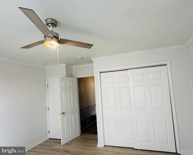 unfurnished bedroom with ornamental molding, a closet, and light wood-type flooring