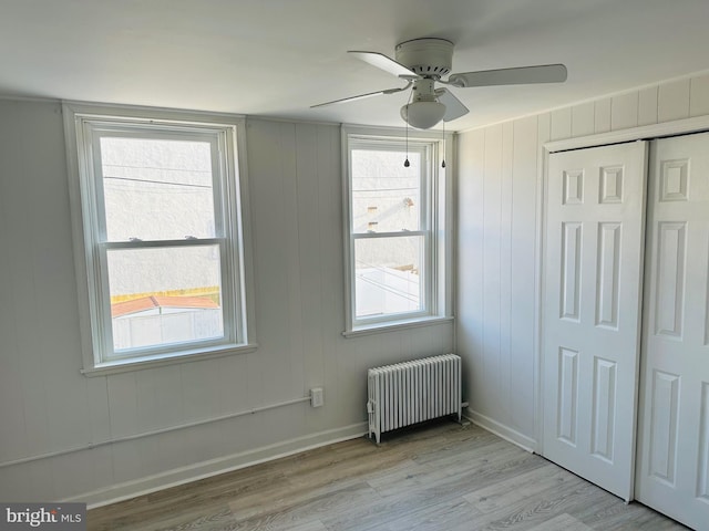 interior space featuring ceiling fan, plenty of natural light, radiator, and light hardwood / wood-style flooring