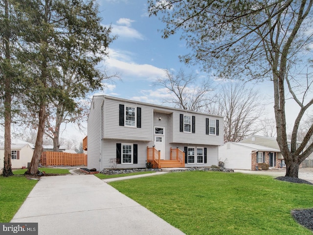 raised ranch featuring a front yard and fence