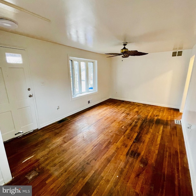 empty room with dark hardwood / wood-style floors and ceiling fan